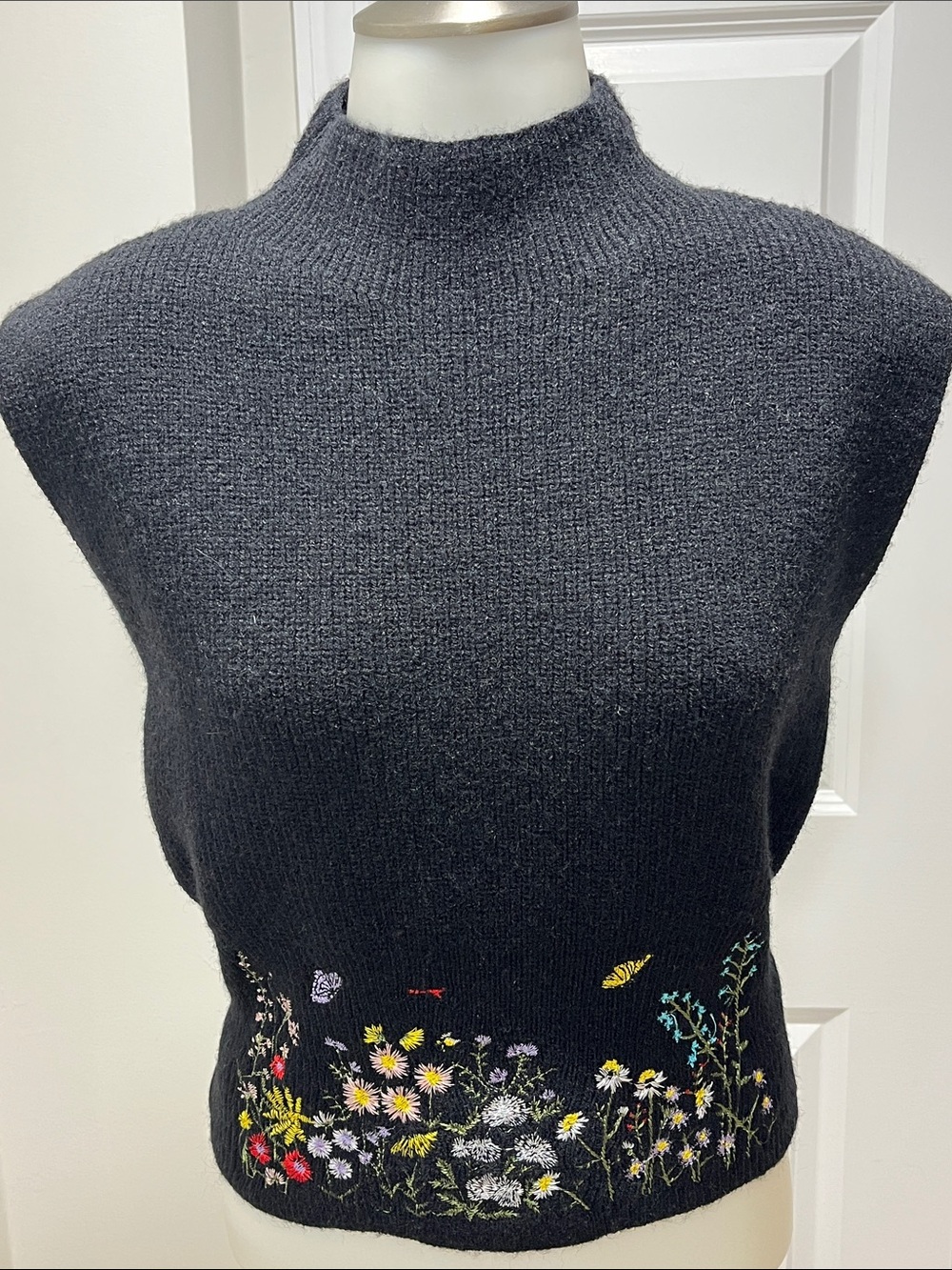 Commence sleeveless black sweater/vest with floral embroidery waist!